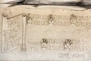 Carving of hand signals on Crystal Ice Company building