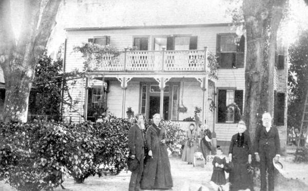 James and Sara Hawthorn in front of oak tree and their home